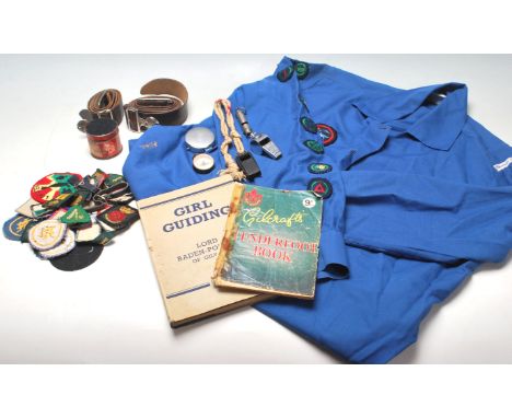 A quantity of vintage 20th Century girl guide related items to include belt, whistle, fabric badges, books, original uniform 