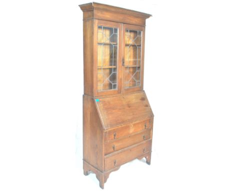 A 1920's Arts &amp; Crafts oak bureau bookcase. The twin door bookcase having astragal glazed doors atop a bureau with&nbsp; 
