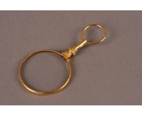 An Edwardian period yellow metal pendant magnifying glass, possibly gold but not marked, also known as a quiz glass with loop