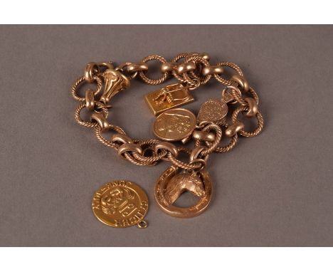 A vintage 9ct gold charm bracelet, with circular twist links supporting several charms including a miniature fob seal, a fire