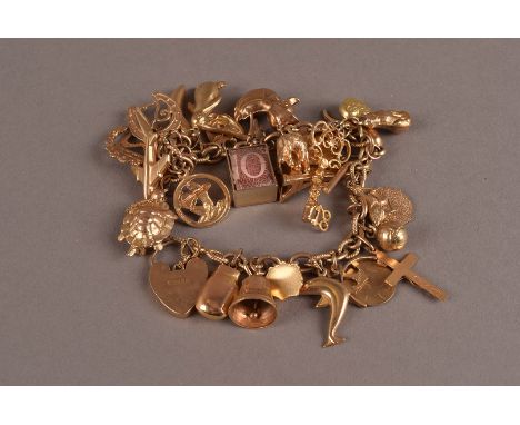 A vintage 9ct gold charm bracelet, the oval link chain supporting numerous charms such as a ten shilling note in case, turtle