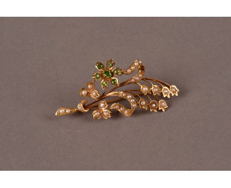 A late Victorian 15ct gold and seed pearl spray brooch, having a flower head set with light green stones and the leaves set w