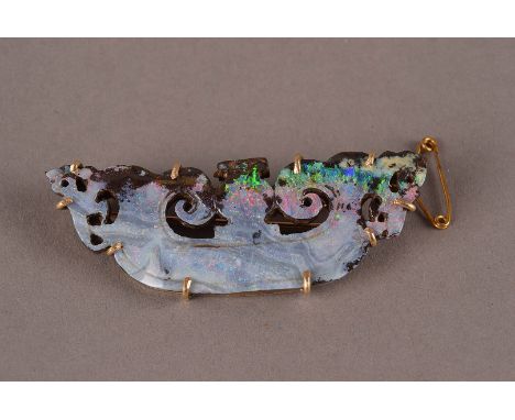 A vintage Russian gold and opal brooch, having a carved and pierced panel of iridescent stone in claw setting mount, marked t