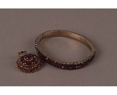 A Victorian garnet set bangle and pendant, possibly in silver, the bangle with two rows of cut red stones, and the pendant of