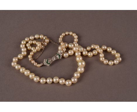 A pretty Art Deco pearl necklace with emerald and diamond clasp, the graduating cultured white pearls with a bow shaped white