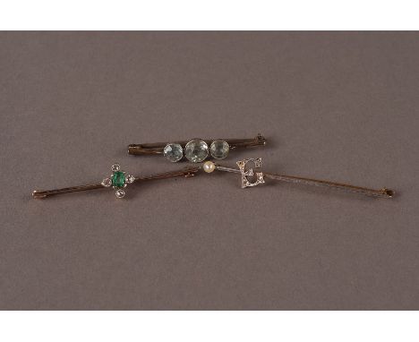 A group of three vintage bar brooches, including an emerald and diamond example, a three stone aqua marine brooch and a bar s