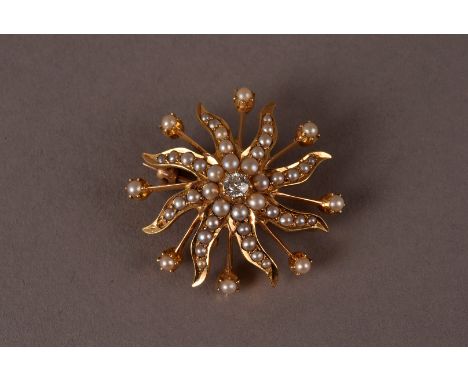 An Edwardian gold and seed pearl brooch cum pendant, the sun burst mount with protruding spikes, encrusted with small white p