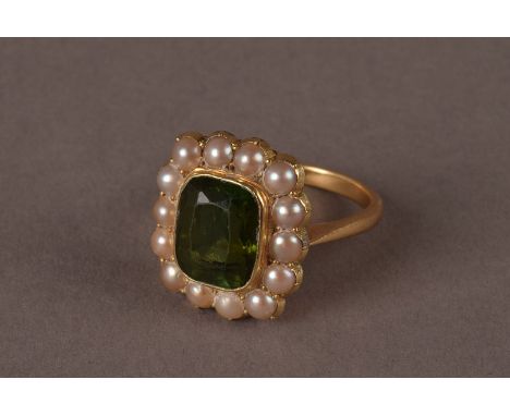 An Edwardian period or later tourmaline and pearl cluster dress ring, the large rectangular cut green stone surrounded by a b