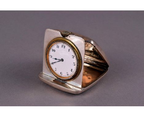 A George V silver travelling timepiece from R & Co, the cushion shaped hinged case opening to reveal fold out panel with watc