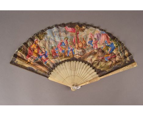 An early 18th century ivory and paper fan, probably Italian, depicting the leaf painted with a serpent interrupting a festiva