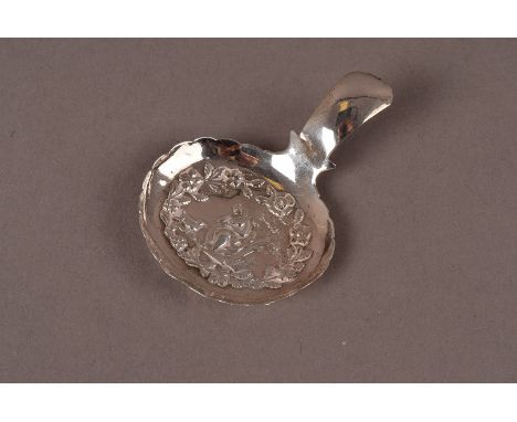 A George IV silver caddy spoon by IB, possibly John Berridge, with scalloped edge bowl having raised design on figure in wood