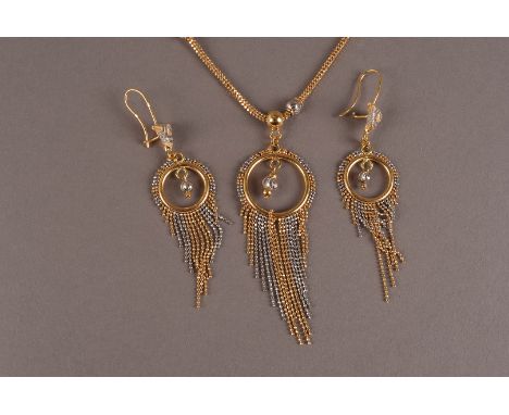 A modern yellow metal necklace and earrings suite of jewellery, the circular pendant with gold and white tassels, having matc