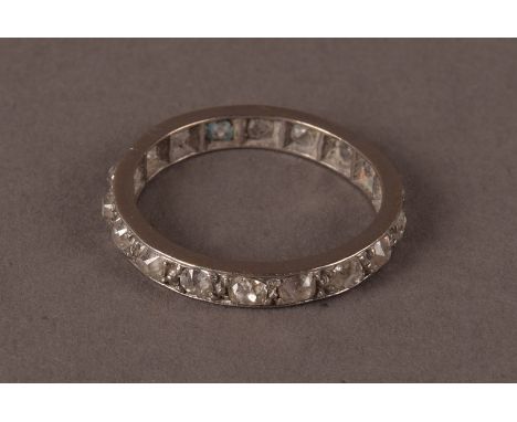 A vintage diamond eternity ring, set with white metal, possibly platinum, and having old cushion cut stones, cracked possibly