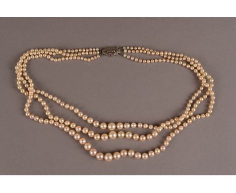 A three strand cultured pearl necklace, with knotted strings of graduating white pearls united by a silver and marcasite clas