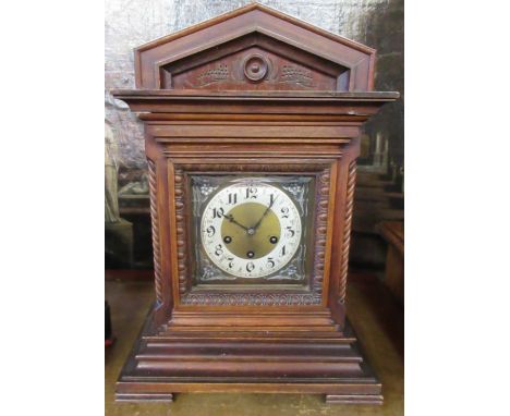 An Edwardian mantel clock, the chiming movement marked Junghans A06, in a carved wooden case, height 18.5ins