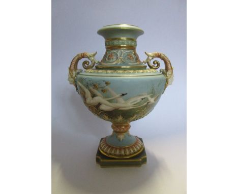 A Royal Worcester vase, decorated with swans in flight by C H C Baldwyn, to a&nbsp;powder blue ground, with swallows to the r