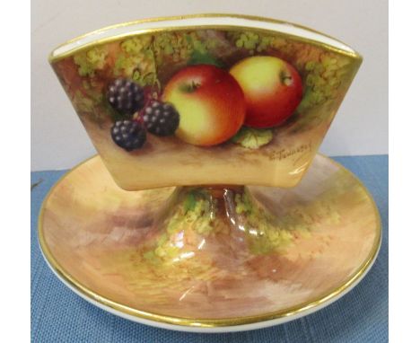 A Royal Worcester painted matchstick holder, the holder raised on a pedestal to a circular dish, decorated with fruit to a mo