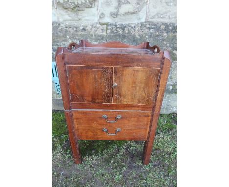 A Georgian mahogany tray top commode, with carrying handle apertures, drop down side flaps, cupboard below and pull out commo