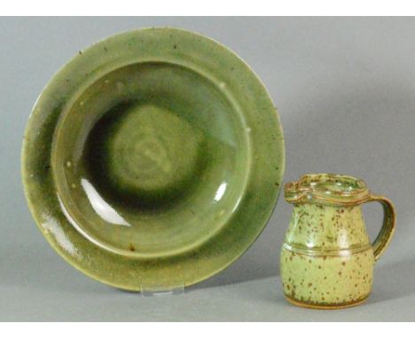 RICHARD BATTERHAM (born 1936); a small stoneware jug covered in green ash glaze, height 11.5cm; and a wide-rimmed bowl by Ray