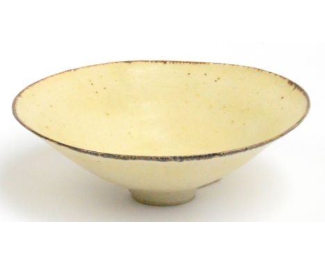 LUCIE RIE (1902-1995); a stoneware dish of flared form covered in a pitted cream glaze with manganese rim and faint concentri