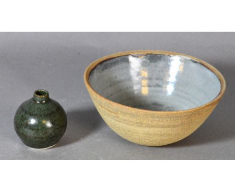 Leach Pottery; a stoneware bowl with grey glazed interior and a porcelain bud vase covered in mottled dark green glaze, impre