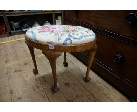 A 1930s walnut oval stool,&nbsp;with tapestry slip in seat and ball and claw feet, 59cm wide.&nbsp; 