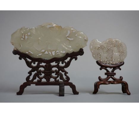 A Chinese carved and pierced celadon jade plaque, decorated with two birds and stylized flowers, 10.5cm wide, on carved and p