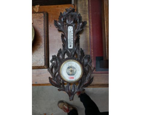 A Black Forest carved wood aneroid wall barometer,&nbsp;47.5cm high.&nbsp; 