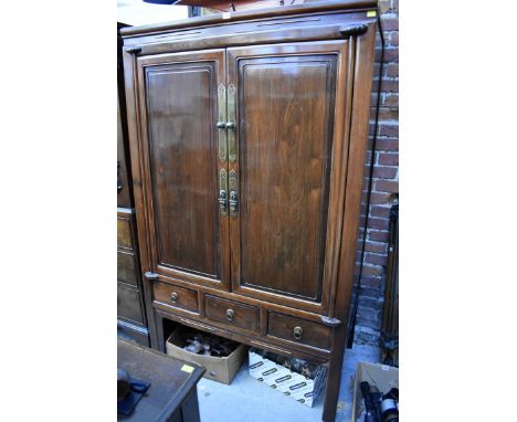 A late 19th/early 20th century Chinese hardwood side cabinet,&nbsp;the pair of panel doors opening to reveal shelves and draw