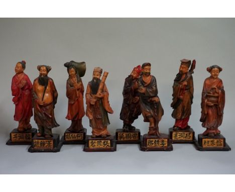A set of eight Chinese carved and stained wood figures,&nbsp;each on inscribed wood base, total height 17.5cm. 