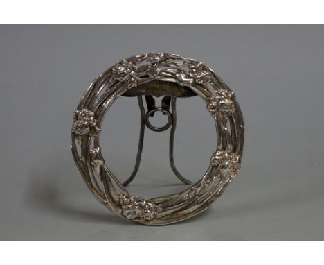 A Chinese silver easel back circular frame,&nbsp;pierced and decorated with floral motifs, aperture 8.9cm diameter, overall 1