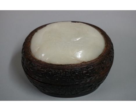 A Chinese hardwood and jade oval box and cover, the inset domed top carved in shallow relief with figures in a landscape, the
