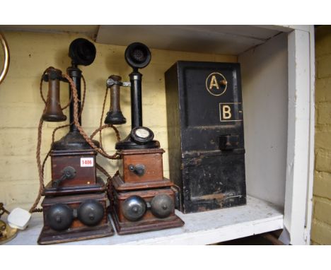 Two vintage candlestick telephones, and wall boxes; together with a vintage telephone kiosk cash box.