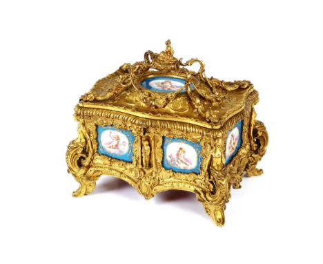 A 19th Century French ormolu trinket casket, inset with Sevres porcelain panels, the hinged lid surmounted by a figure seated