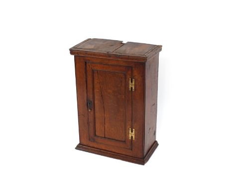 An 18th Century oak hanging spice cupboard, enclosed by a single panelled door, 50cm wide x 70cm high