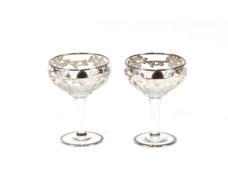 A pair of good quality cut glass and silvered overlay champagne saucers; and a pair of hobnail cut glass rummers on square ba