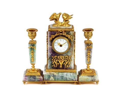 A 19th Century French Fluorspar and ormolu clock garniture, the timepiece surmounted by doves above applied foliate and ribbo