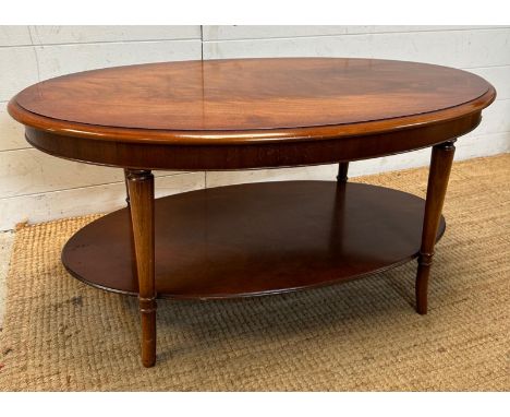 An oval coffee table with shelf under 