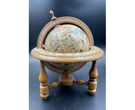 A small desk top globe in a wooden frame 