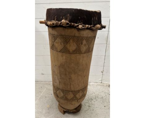 A wooden carved West African drum with hide drum skin and travel case