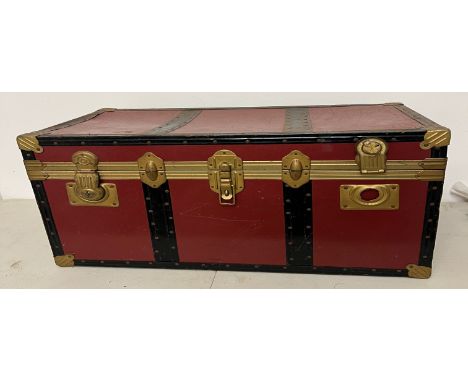 Red and black travel trunk with brass bound 