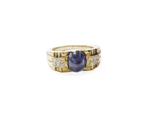 A Sapphire and Diamond Ring, the oval cabochon sapphire flanked by six old cut diamonds to each side, in white pavé settings,