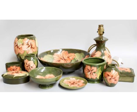 Walter Moorcroft Pottery, various shapes in the "Coral Hibiscus" design on green grounds, (11)