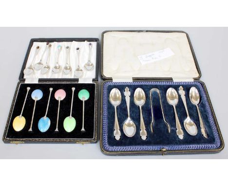 Two Cased Sets of Six Silver Teaspoons, one set with enamelled bowls and one set cased with a pair of sugar-tongs; Together W
