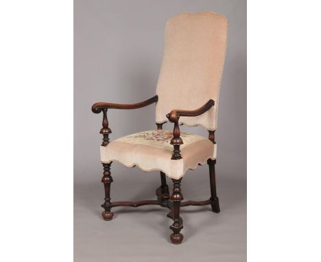 An early 19th century carved walnut upholstered arm chair. Having x-frame stretcher with centre finial. Height of back 123cm,