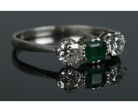 An Art Deco platinum, diamond and emerald ring. Size M. 2.57g. Total diamond approximately 0.5ct.  