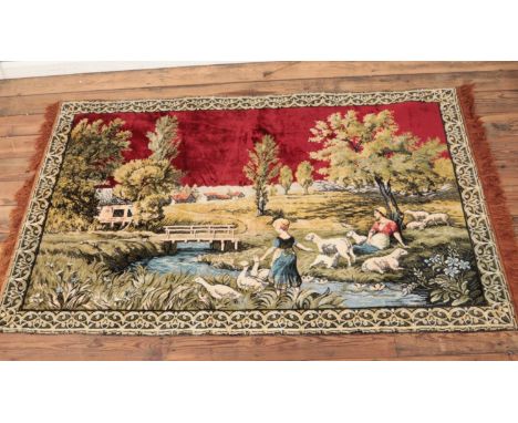 A wool tapestry with frilled edges depicting two figures amongst geese and sheep within a farm, on burgundy red background. H