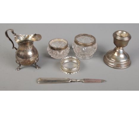 A small quantity of silver. Includes weight dwarf candlestick, napkin ring, silver cream jug, etc.  