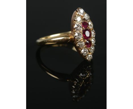 An 18ct gold diamond and ruby navette ring. The three graduating ruby stones within a border of twelve diamonds. Size N. 4.48