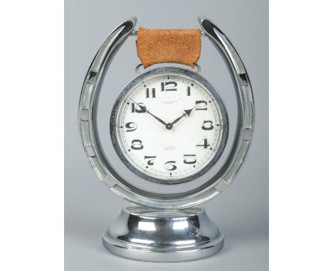 A Swaine &amp; Adeney 8 day clock suspended on chrome horse shoe stand. Height 16cm.  Running.